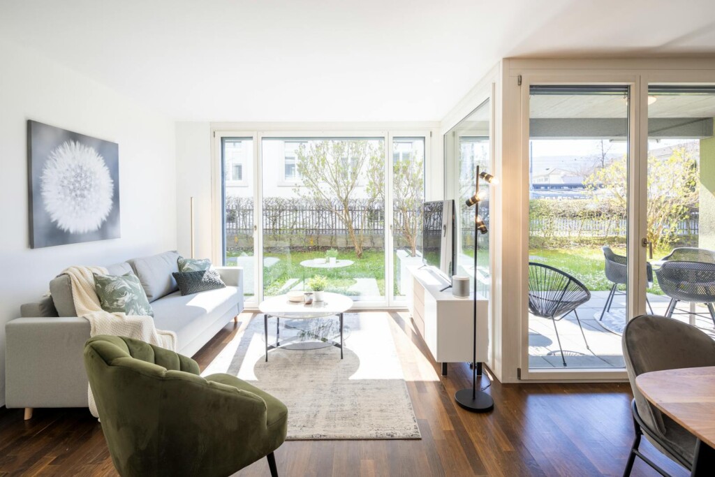 Living room with garden access at STAYY Mitten im Gr&uuml;n in Dietikon